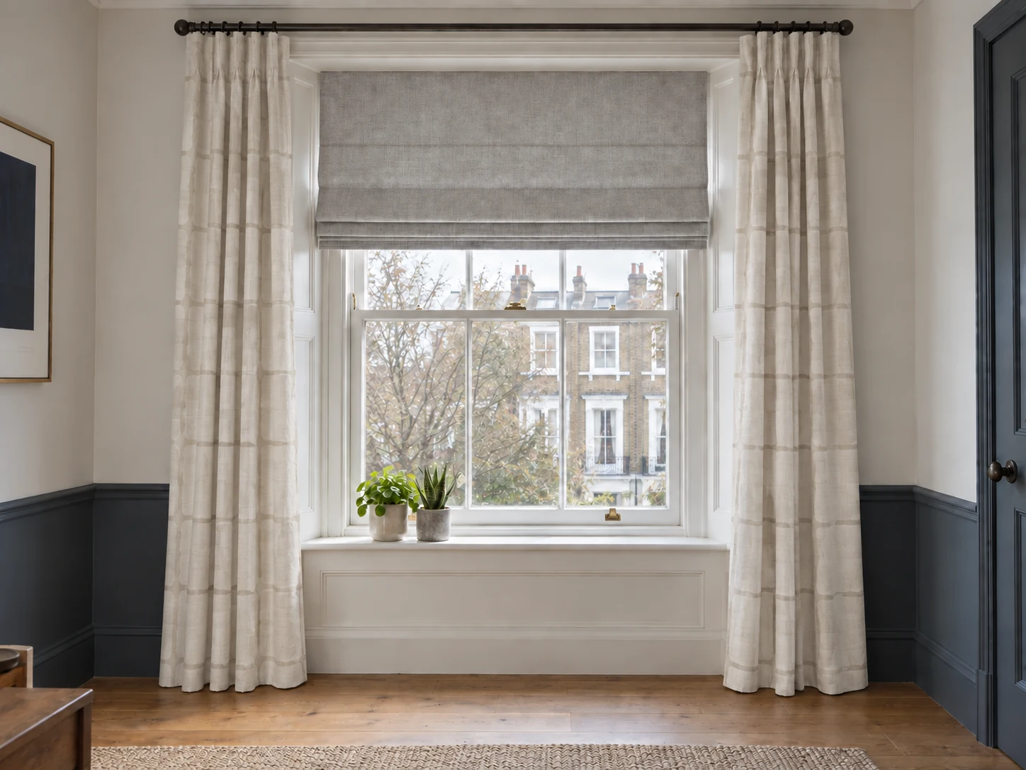 Cream checked curtains and a Roman blind fitted to a sash window