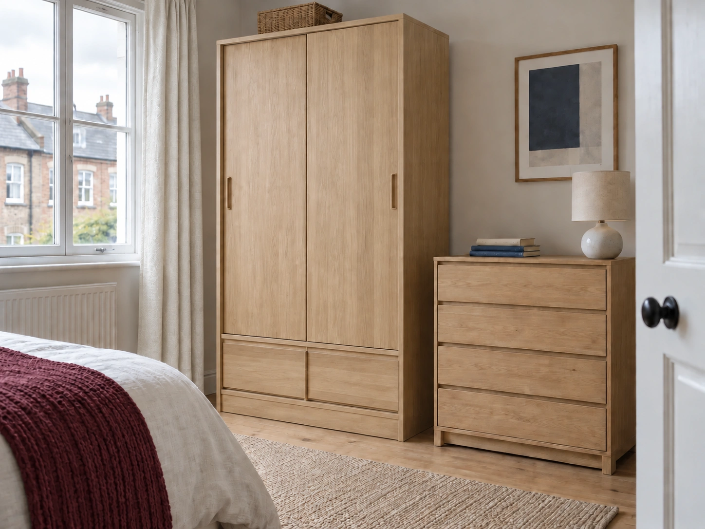 Oak wardrobe with sliding doors and bottom drawers beside a chest of drawers